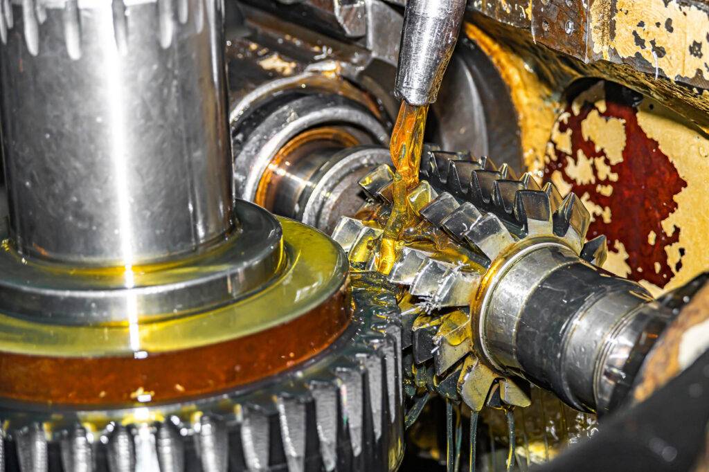 Engineer inspecting industrial machinery to demonstrate how premium industrial lubricants reduce equipment wear, maintenance costs and downtime.